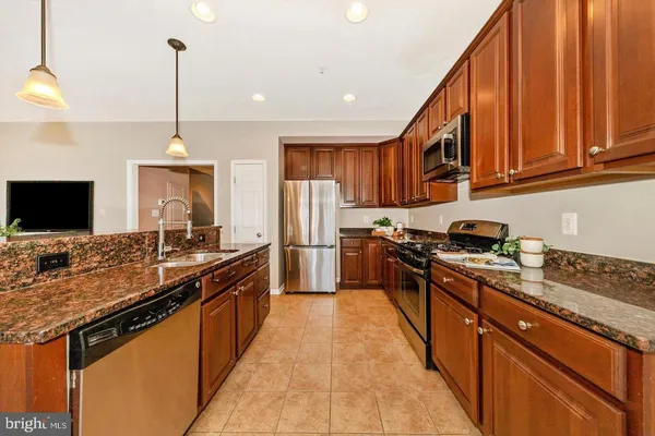 a kitchen with stainless steel appliances granite countertop a stove a sink and a refrigerator