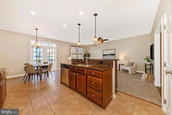 a kitchen with stainless steel appliances granite countertop a stove a sink a dining table chairs and chandelier