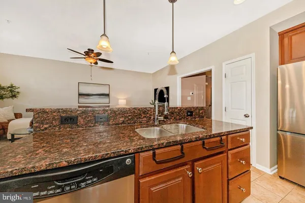 a kitchen with stainless steel appliances granite countertop a sink a stove and a refrigerator
