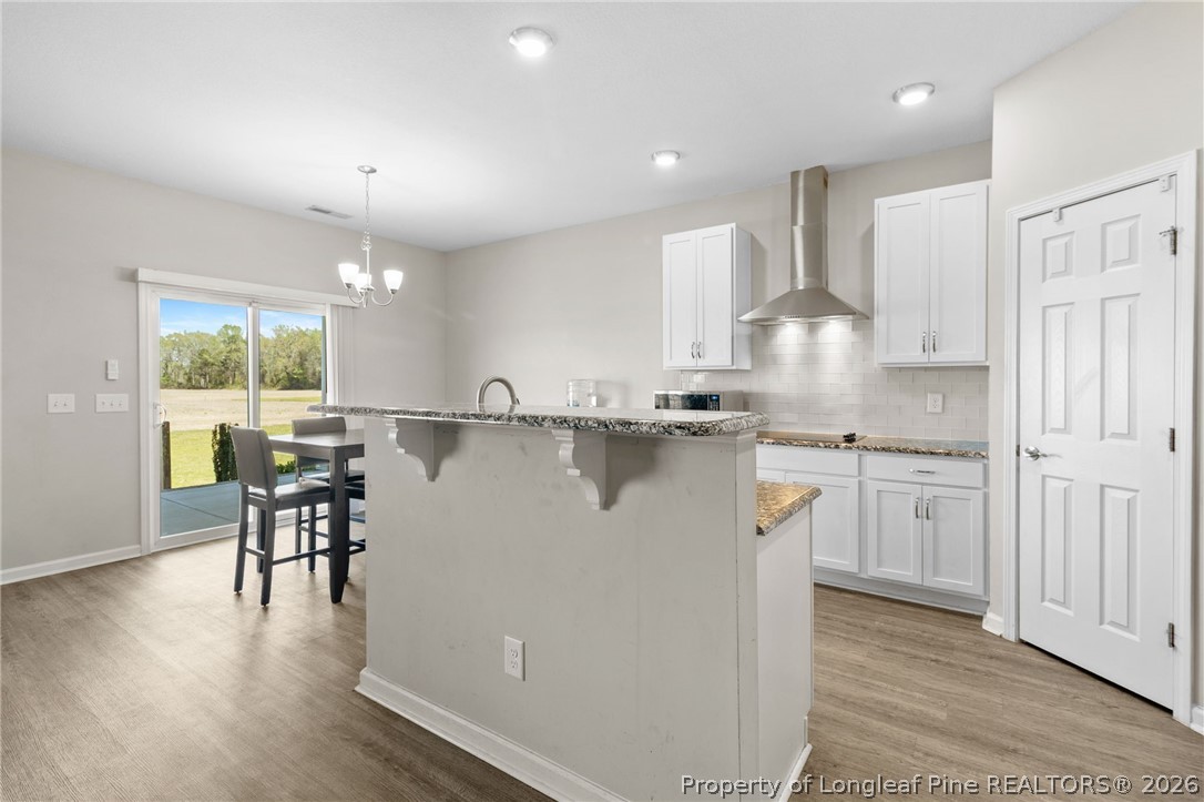 3298 Deep Branch Road Lumberton, NC 28360 - Photo 15 of 41 a kitchen with kitchen island granite countertop wooden floors and white stainless steel appliances