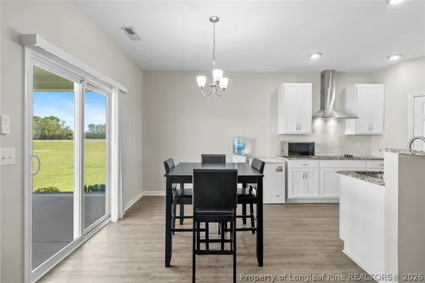 a kitchen with stainless steel appliances granite countertop a stove top oven a sink dishwasher and a refrigerator with wooden floor