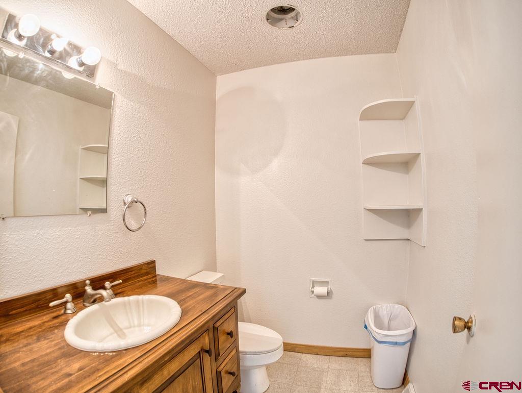 27980 Rd T Dolores, CO 81323 - Photo 17 of 29 a bathroom with a granite countertop sink a toilet and a mirror