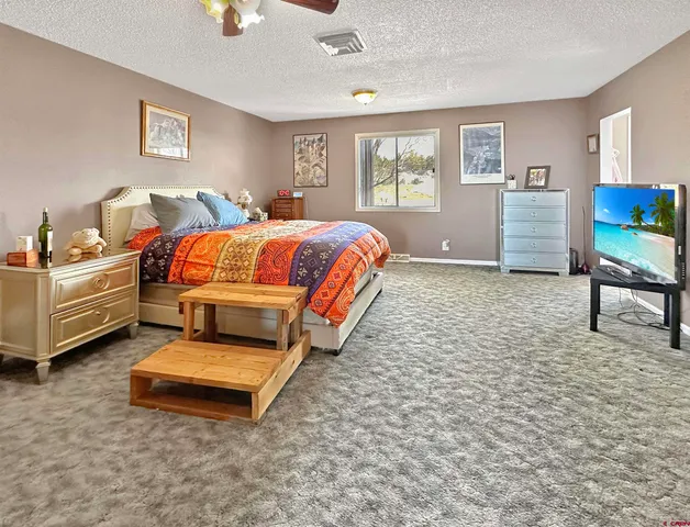 a spacious bedroom with a bed and a table in it