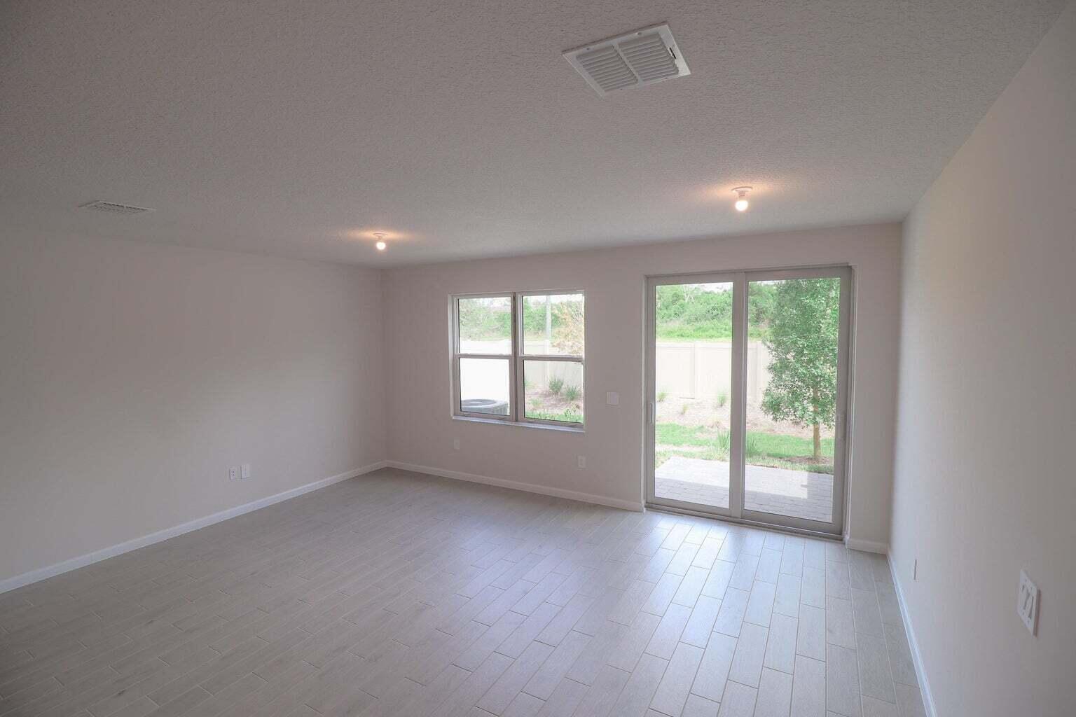 357 Southeast Angler Drive Stuart, FL 34994 - Photo 13 of 25 an empty room with wooden floor and windows