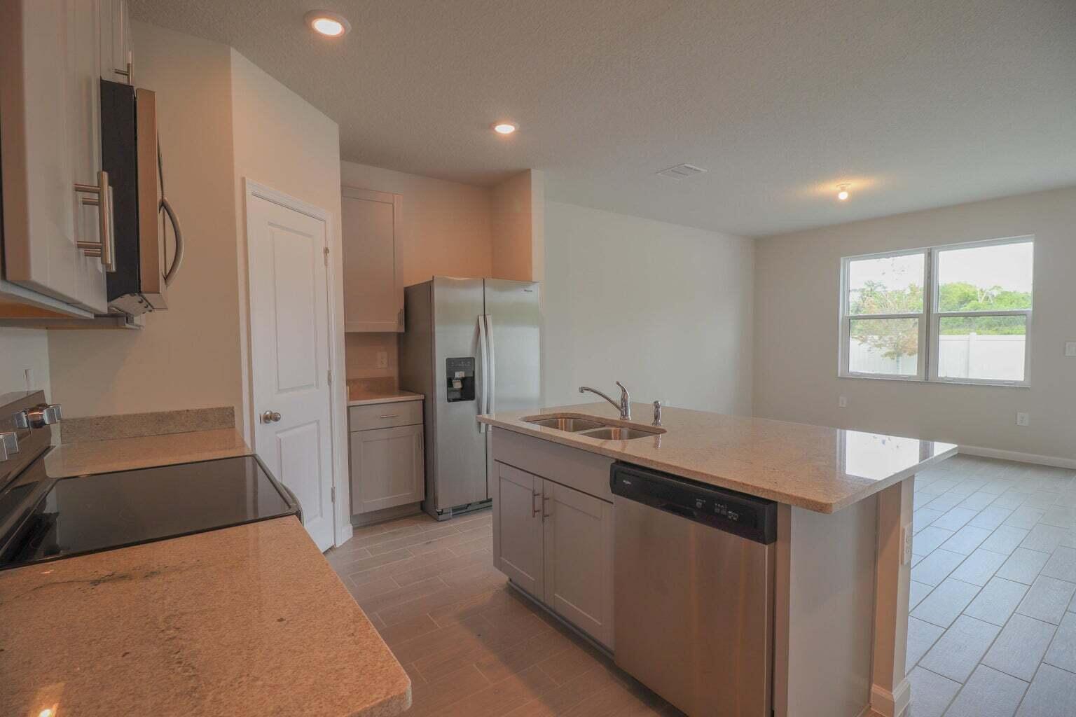 357 Southeast Angler Drive Stuart, FL 34994 - Photo 5 of 25 a kitchen with stainless steel appliances granite countertop a sink stove and refrigerator