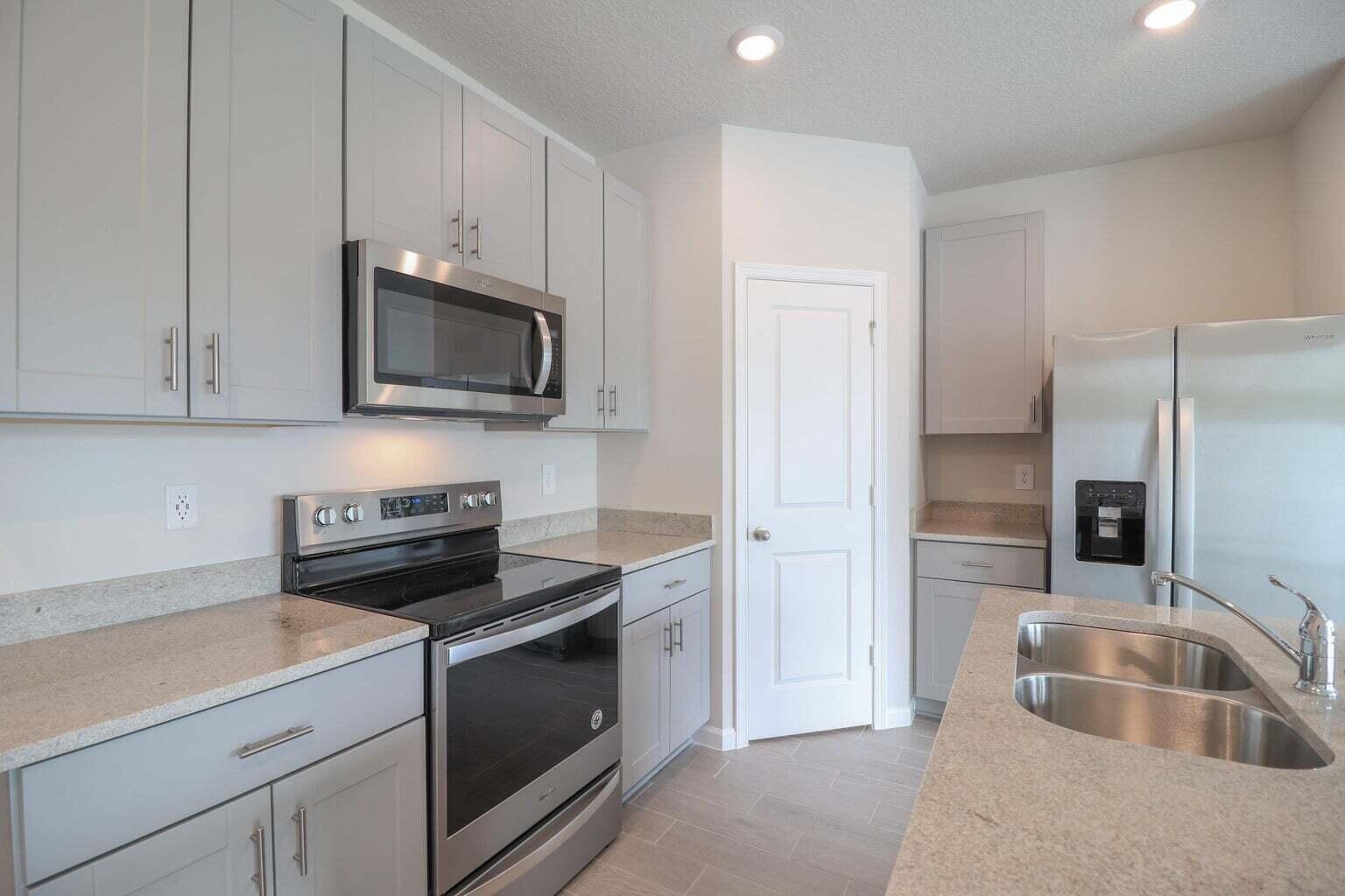 357 Southeast Angler Drive Stuart, FL 34994 - Photo 6 of 25 a kitchen with cabinets stainless steel appliances and a sink