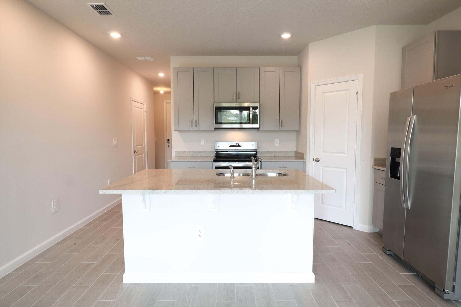 357 Southeast Angler Drive Stuart, FL 34994 - Photo 8 of 25 a kitchen with kitchen island a sink stainless steel appliances and cabinets