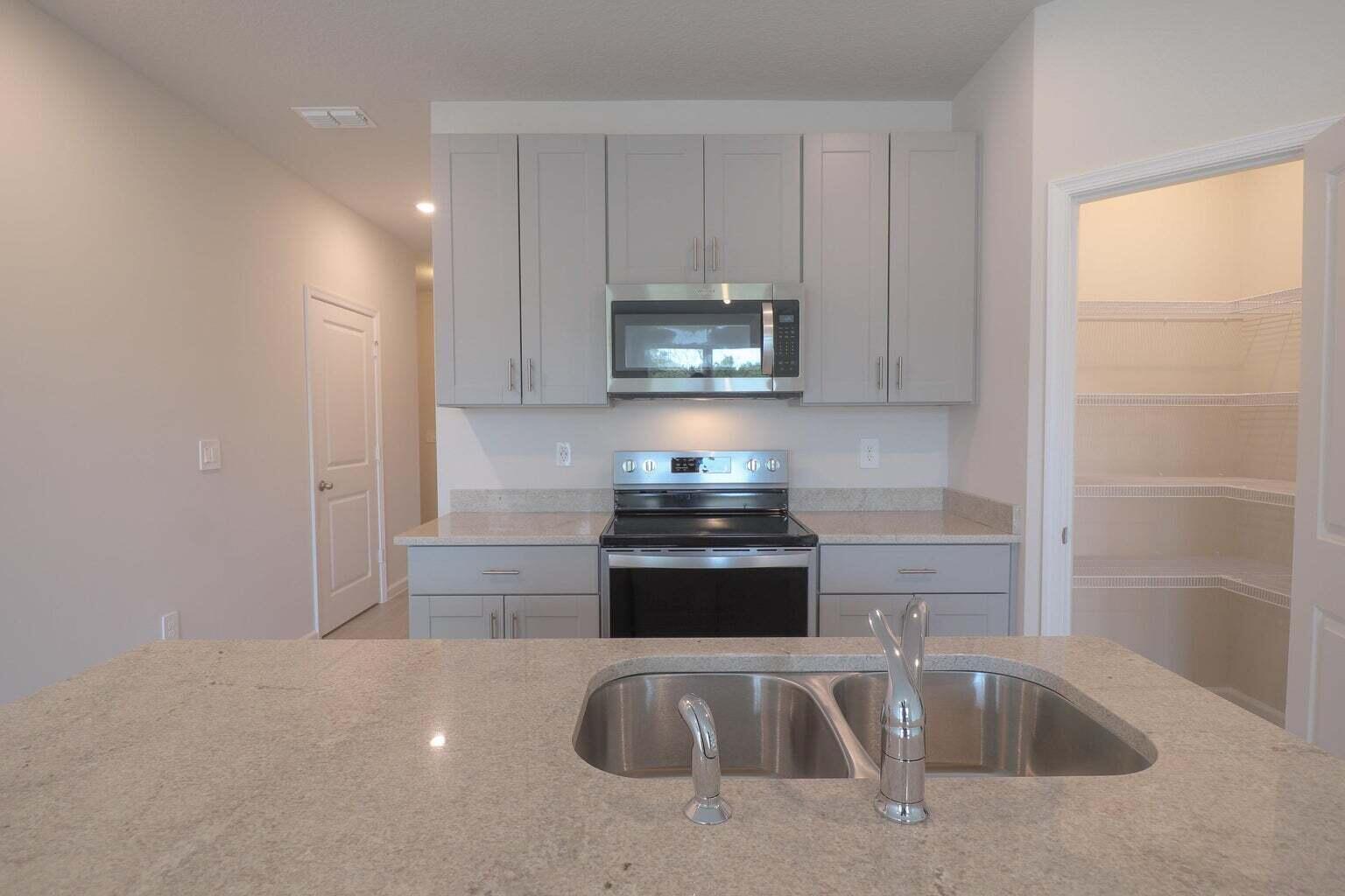 357 Southeast Angler Drive Stuart, FL 34994 - Photo 9 of 25 a kitchen with granite countertop a sink and a stove top oven