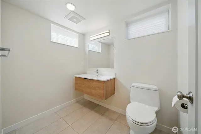 a bathroom with a toilet a sink and mirror