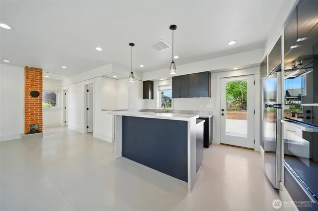 a kitchen with kitchen island a sink stainless steel appliances and cabinets
