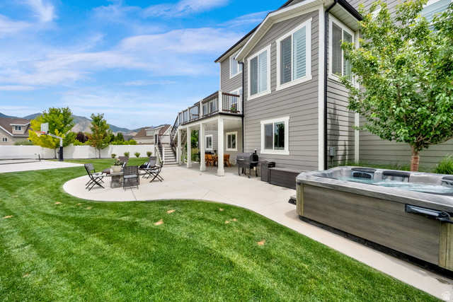 1132 South 1300th Street West Mapleton, UT 84664 - Photo 41 of 52 Expansive backyard featuring a large hot tub, a curved concrete patio with an outdoor fire pit, a basketball court, an upper-level deck, and a covered lower-level patio