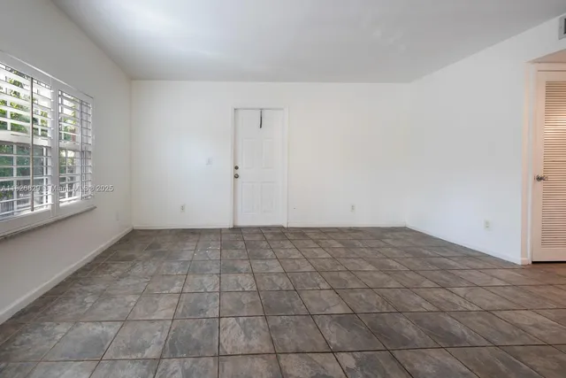 a view of an empty room and window in an empty room