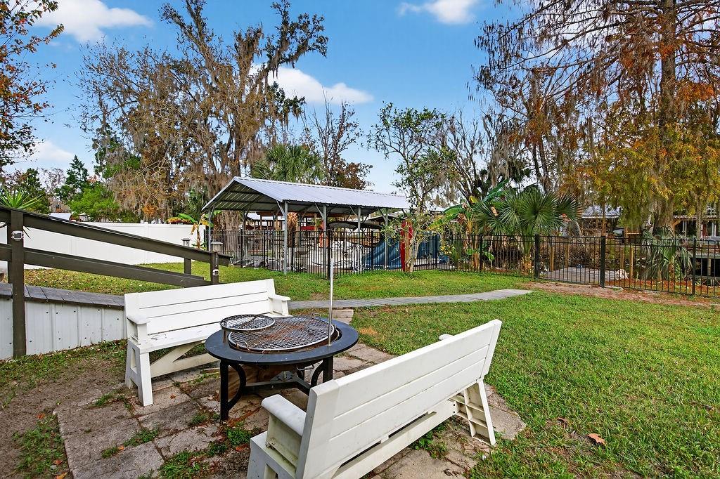 56320 Cherry Tree Road Astor, FL 32102 - Photo 19 of 40 a view of a table and chairs in backyard of the house