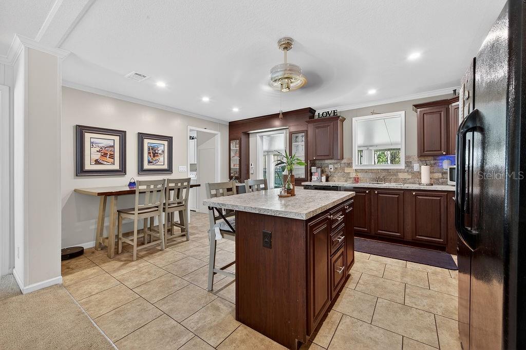 56320 Cherry Tree Road Astor, FL 32102 - Photo 29 of 40 a kitchen with stainless steel appliances granite countertop a sink counter space cabinets and a large window