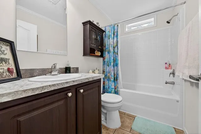 a bathroom with a granite countertop sink a toilet and shower
