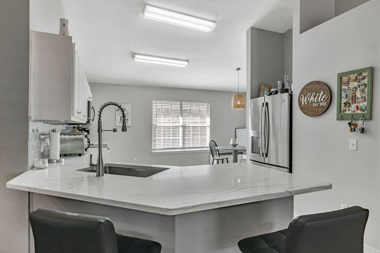 9761 Leeward Way Navarre, FL 32566 - Photo 11 of 43 a bathroom with a sink and a large mirror