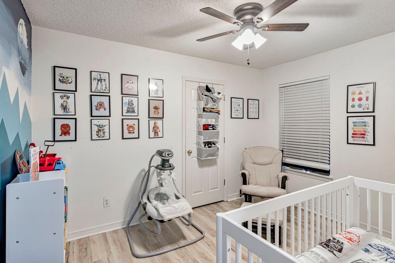 9761 Leeward Way Navarre, FL 32566 - Photo 23 of 43 a bedroom with furniture and wooden floor