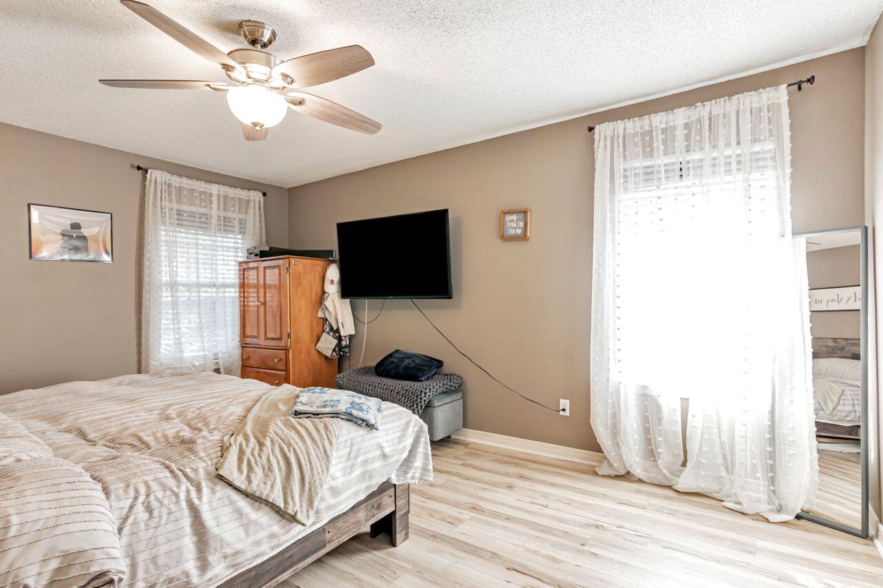 9761 Leeward Way Navarre, FL 32566 - Photo 24 of 43 a bedroom with a bed flat screen tv and a window