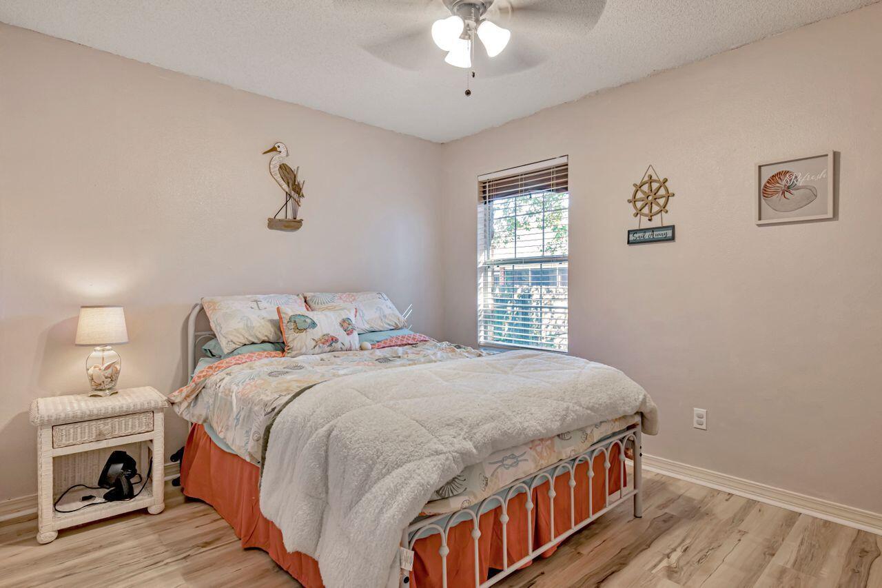 9761 Leeward Way Navarre, FL 32566 - Photo 27 of 43 a bedroom with a large bed and a chandelier