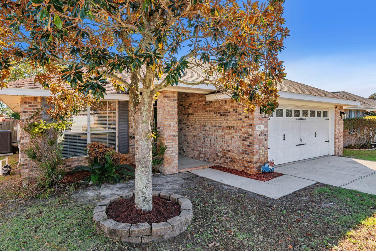 9761 Leeward Way Navarre, FL 32566 - Photo 3 of 43 a front view of a house with a yard