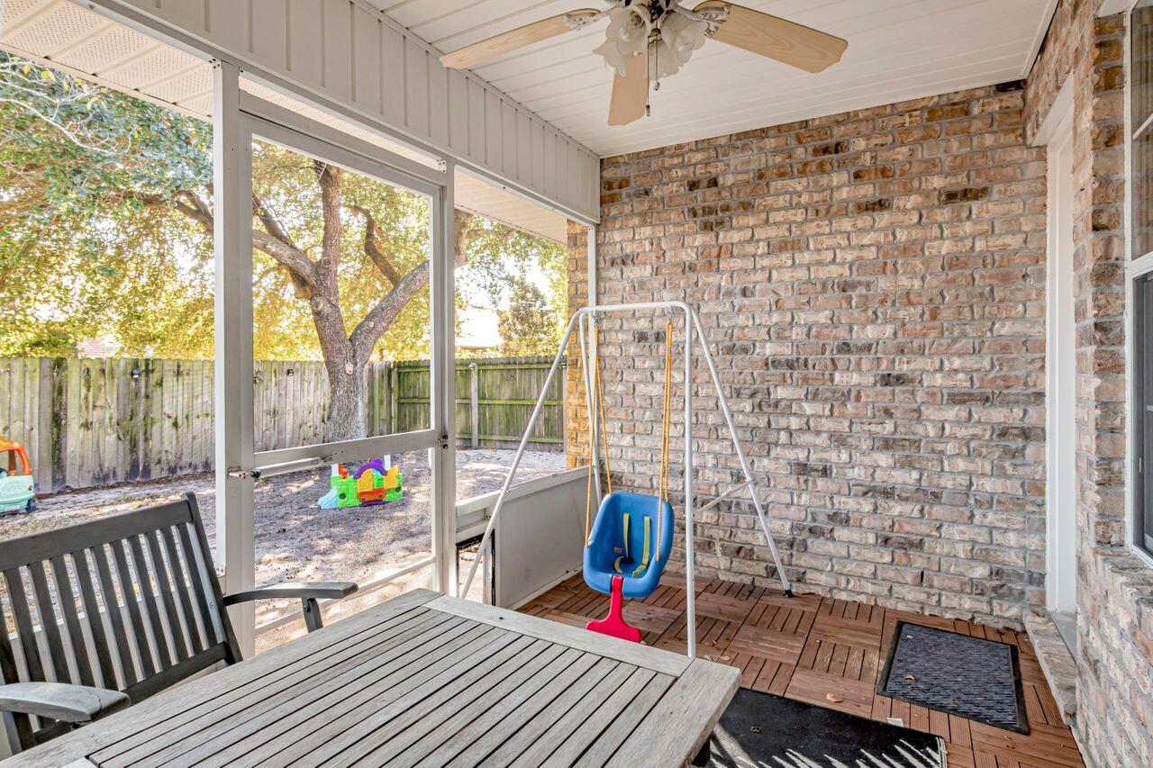 9761 Leeward Way Navarre, FL 32566 - Photo 33 of 43 a living room with furniture and a floor to ceiling window