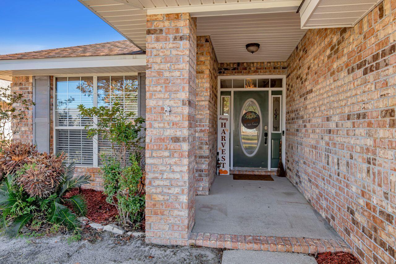 9761 Leeward Way Navarre, FL 32566 - Photo 4 of 43 a front view of a house with garden