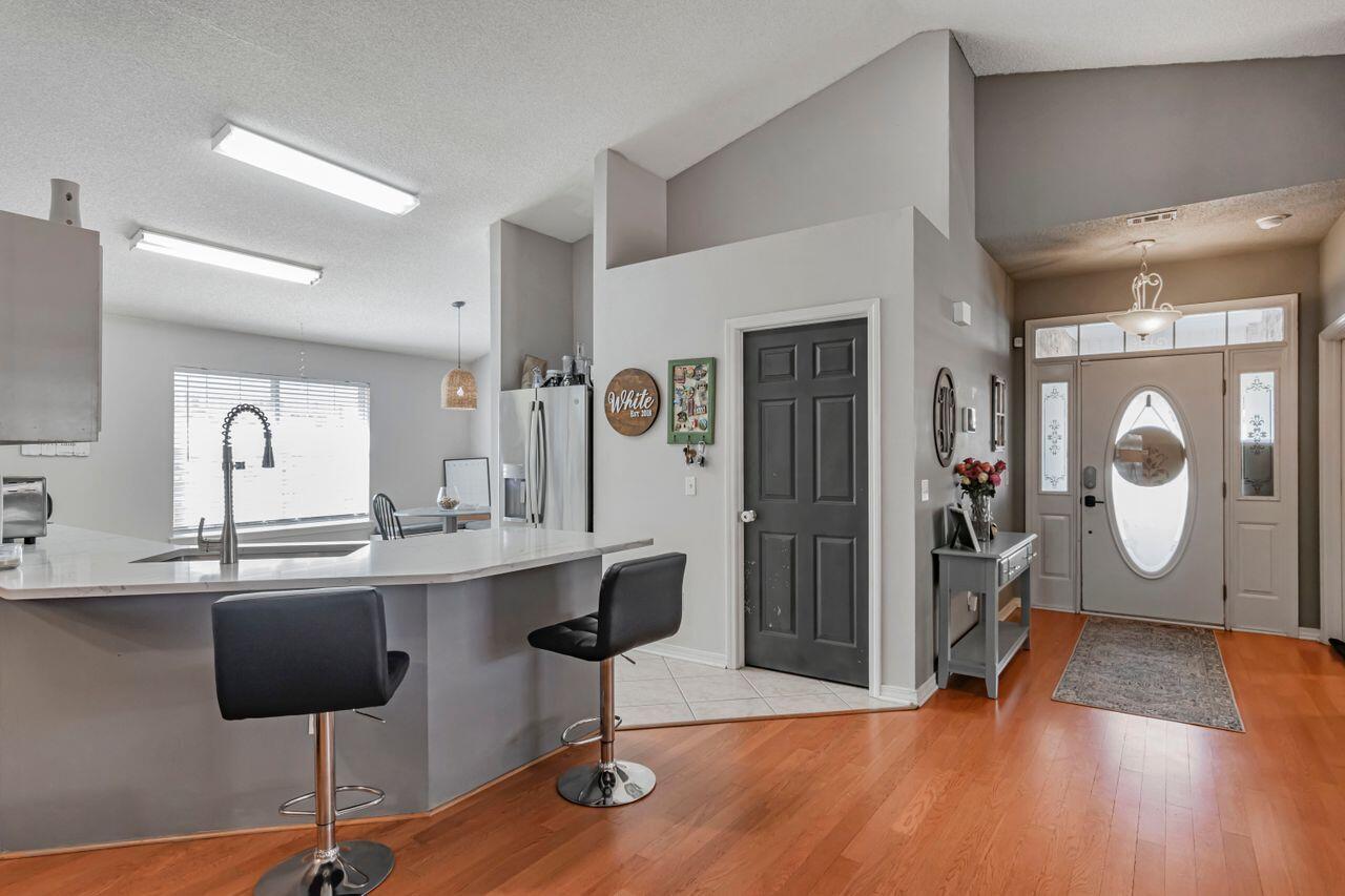 9761 Leeward Way Navarre, FL 32566 - Photo 10 of 43 a view of a kitchen area with furniture and wooden floor