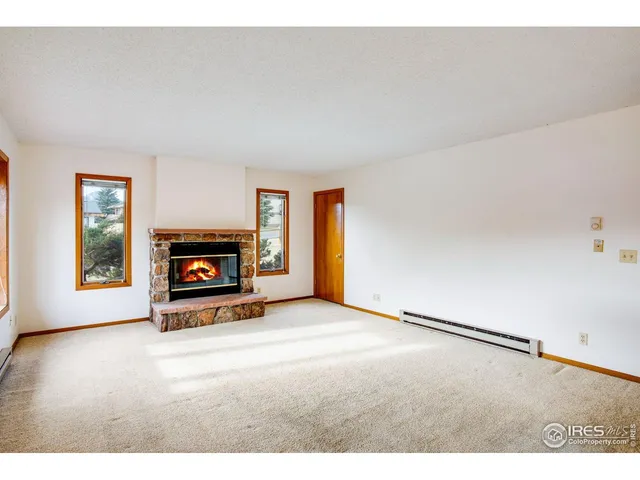 a view of an empty room with a fireplace and a window