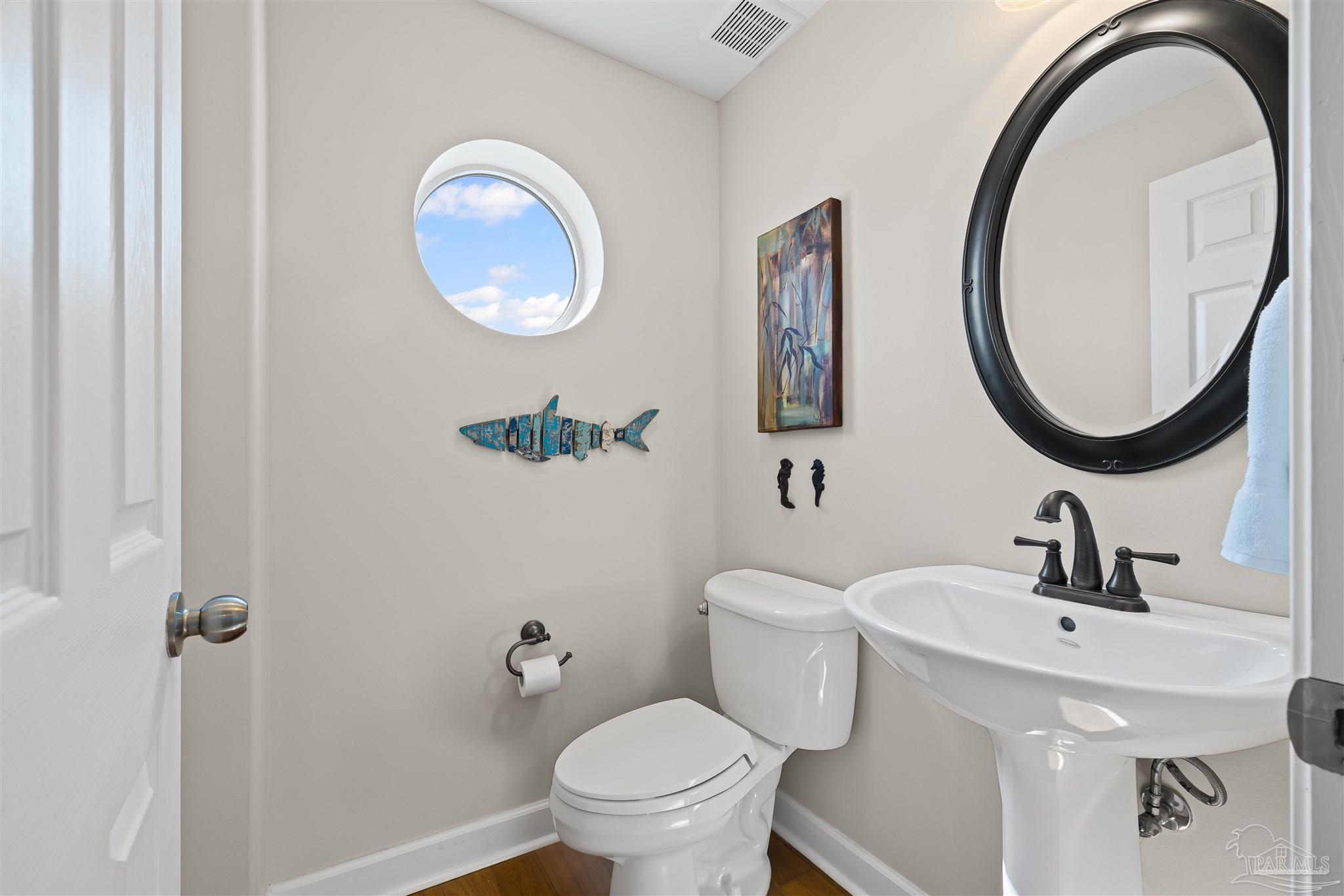 1299 Fort Pickens Road, Unit 10 Pensacola Beach, FL 32561 - Photo 16 of 58 a bathroom with a toilet a sink and a mirror