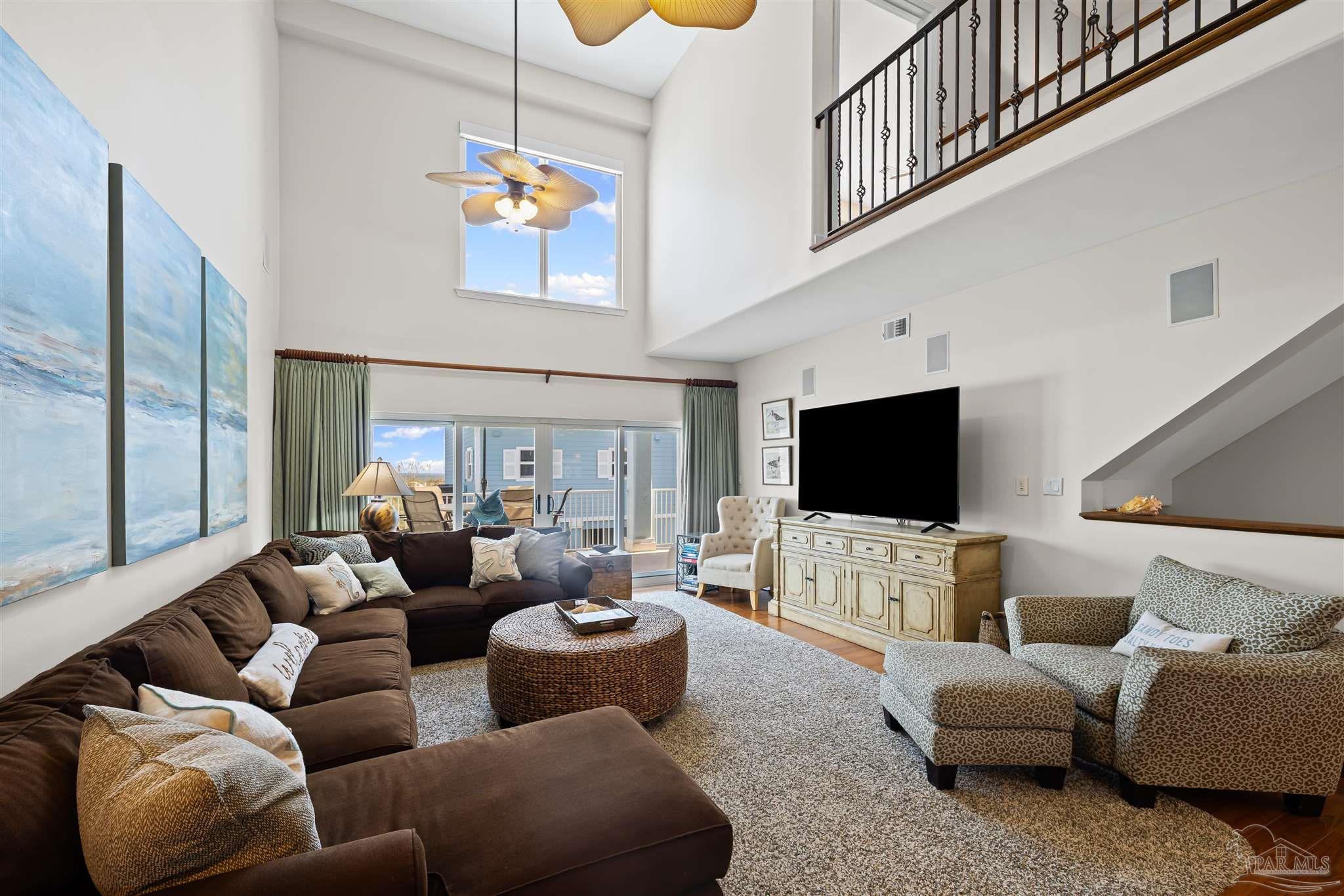 1299 Fort Pickens Road, Unit 10 Pensacola Beach, FL 32561 - Photo 2 of 58 a living room with furniture and a flat screen tv
