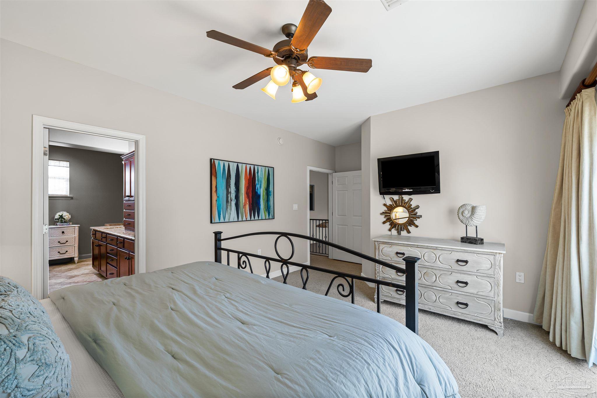 1299 Fort Pickens Road, Unit 10 Pensacola Beach, FL 32561 - Photo 21 of 58 a bedroom with a bed and a flat screen tv
