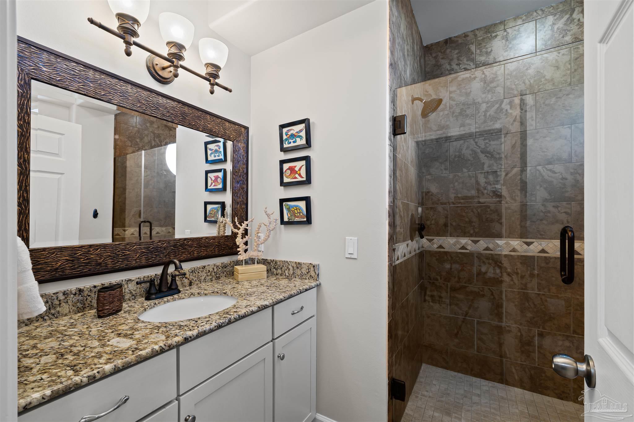 1299 Fort Pickens Road, Unit 10 Pensacola Beach, FL 32561 - Photo 27 of 58 a bathroom with a granite countertop sink mirror and shower