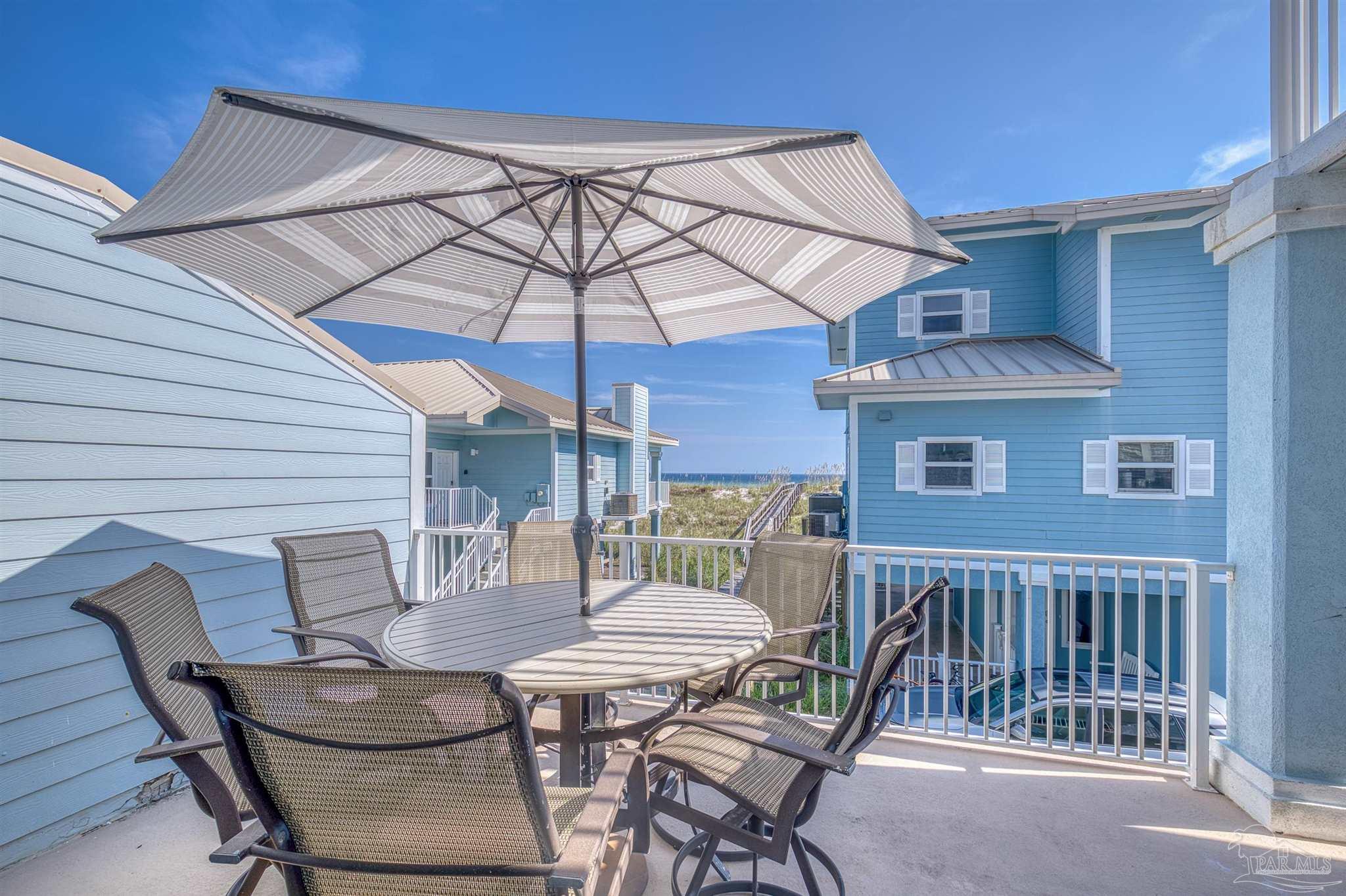 1299 Fort Pickens Road, Unit 10 Pensacola Beach, FL 32561 - Photo 33 of 58 a table and chairs in patio of the house