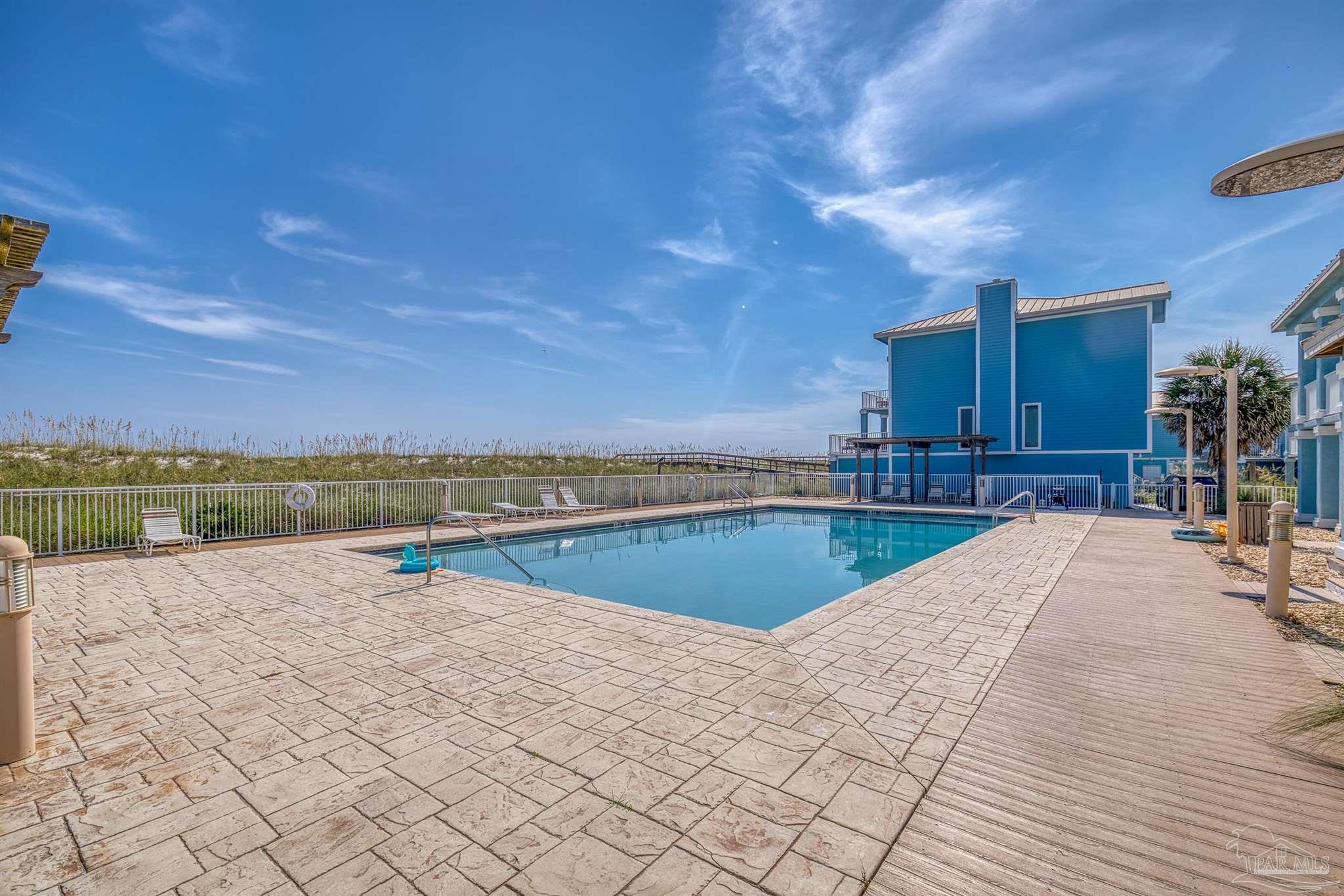 1299 Fort Pickens Road, Unit 10 Pensacola Beach, FL 32561 - Photo 44 of 58 a view of a swimming pool and lounge chair