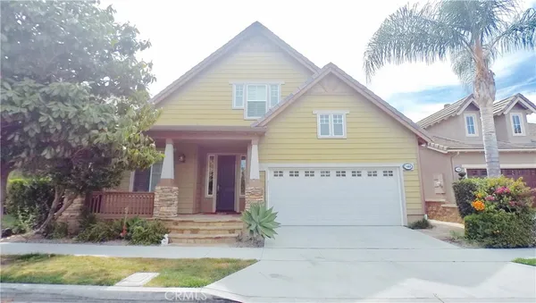 a front view of a house with a garden and plants