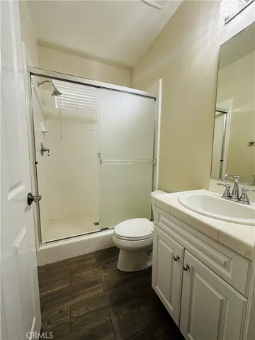 a bathroom with a sink a toilet a shower and a mirror