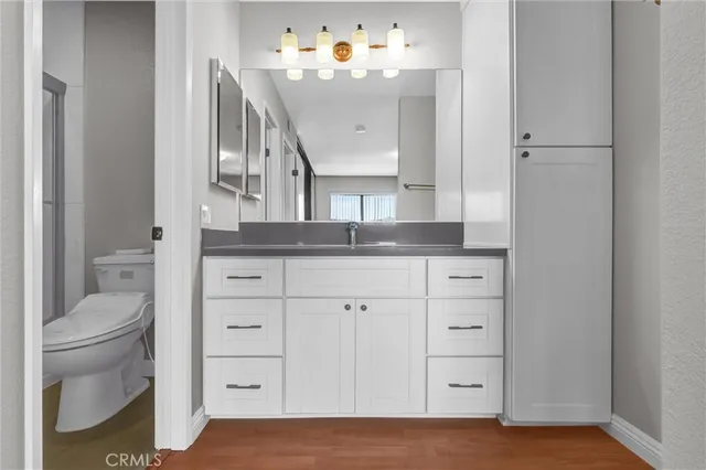 a bathroom with a sink a toilet and shower