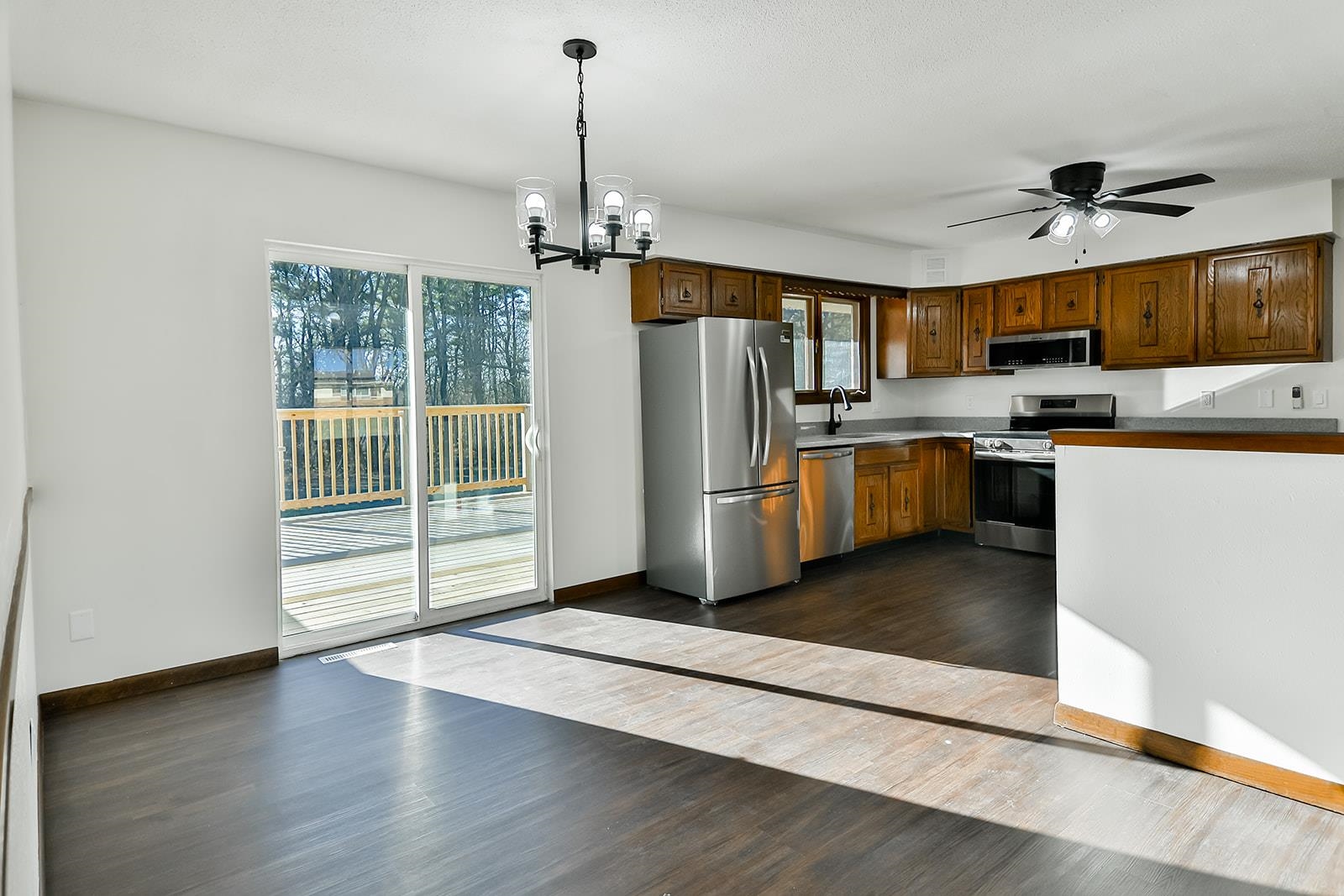 8567 Valley View Drive Stillman Valley, IL 61084 - Photo 32 of 36 a kitchen with stainless steel appliances granite countertop a refrigerator a sink dishwasher a stove and a dining table with wooden floor