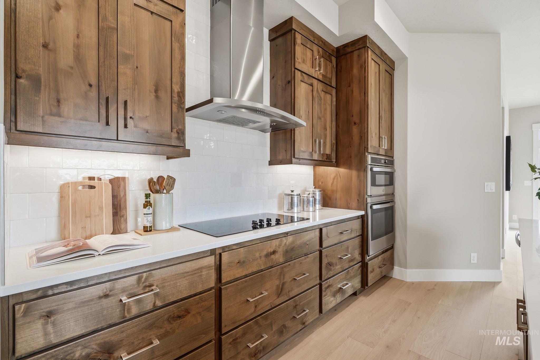 470 South Radiator Way Boise, ID 83716 - Photo 25 of 50 Kitchen featuring natural wood cabinetry, stainless steel appliances, a white subway tile backsplash, light wood-finish flooring, and white countertops