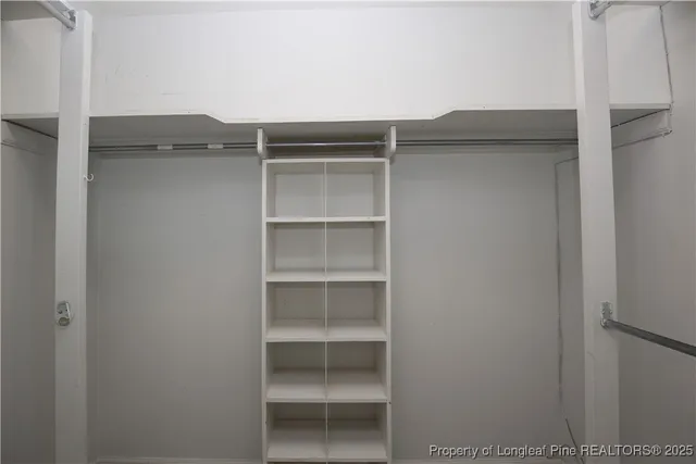 a view of walk in closet with empty racks