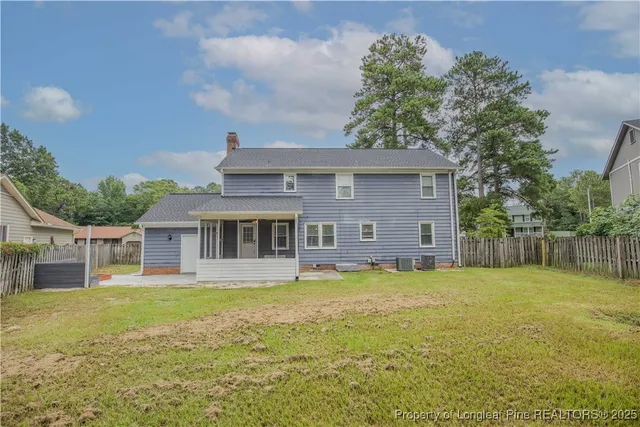 a front view of house with yard and trees in the background