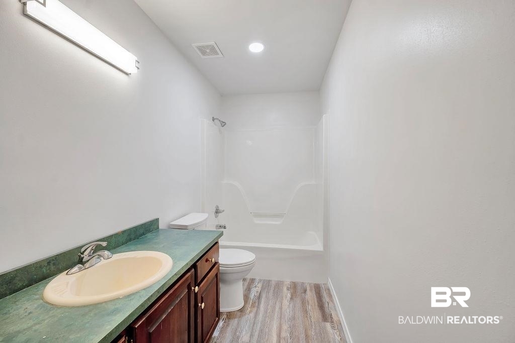 31246 Shambo Road Daphne, AL 36527 - Photo 20 of 26 Bathroom featuring wood finished floors, vanity, and tub / shower combination