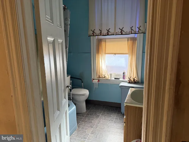 a bathroom with a toilet a sink and a window