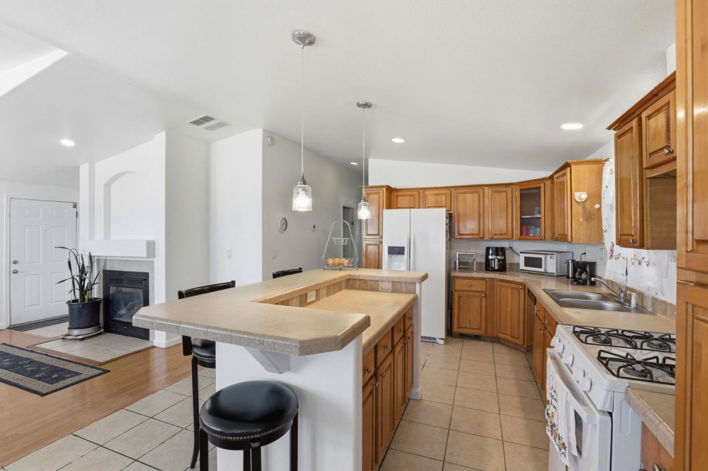 500 West 10th Street, Unit 119 Gilroy, CA 95020 - Photo 5 of 27 a kitchen with a stove a sink dishwasher and a refrigerator with wooden floor