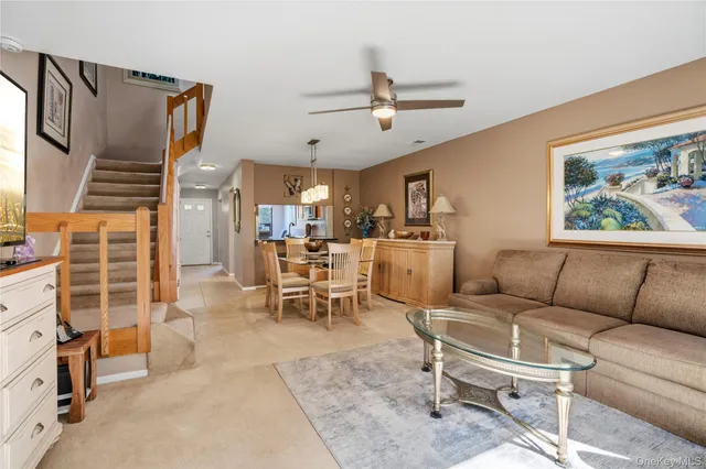 a living room with furniture a rug and white walls