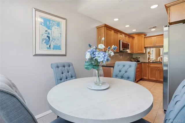 a dining room with furniture a chandelier and kitchen view