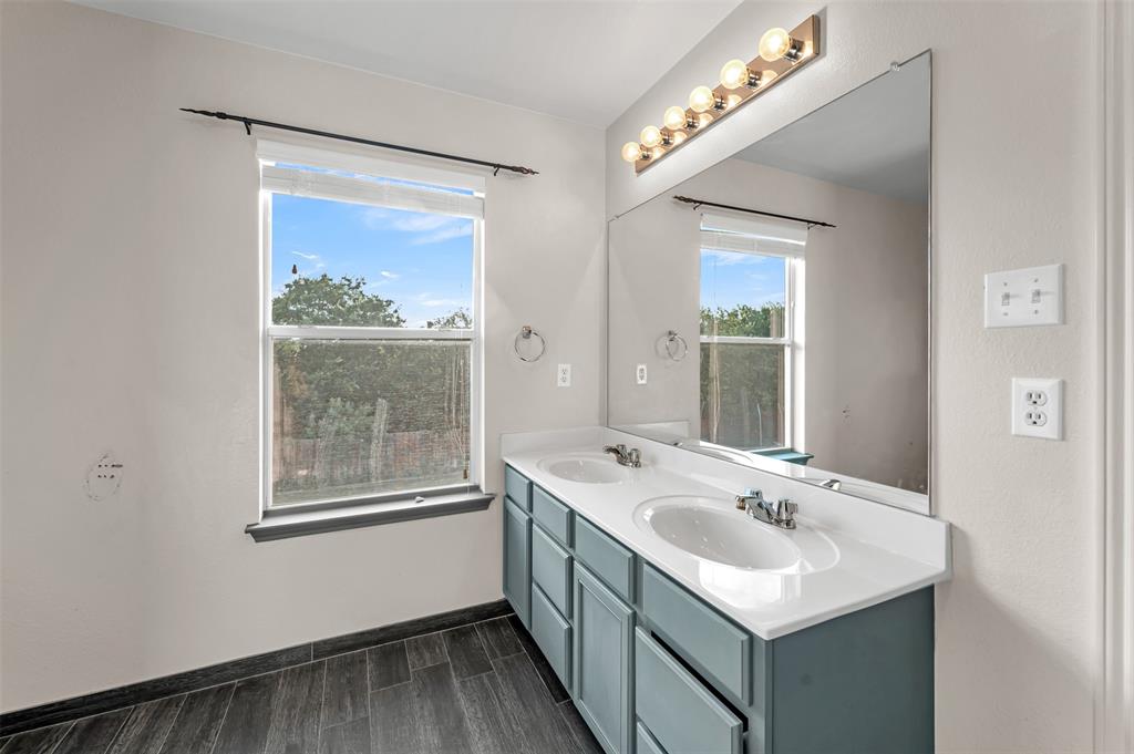 9017 Graywolf Ridge Trail Fort Worth, TX 76244 - Photo 25 of 27 Bathroom with double sink vanity and hardwood / wood-style floors