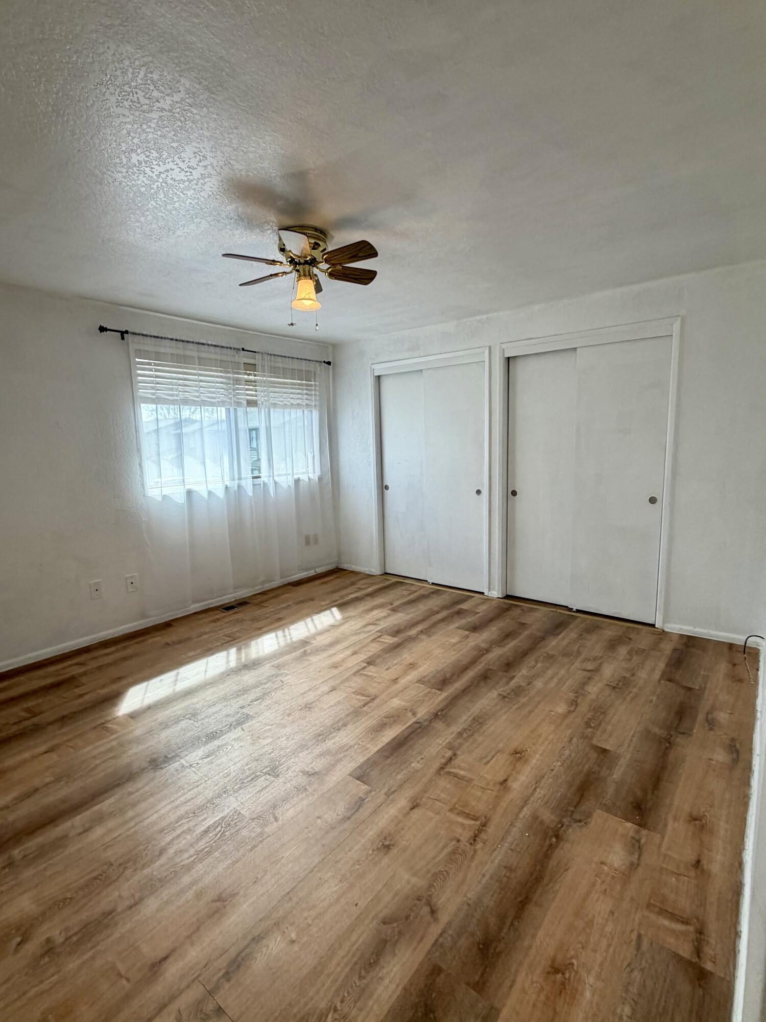 1198 Morrow Road, Unit A Medford, OR 97504 - Photo 18 of 20 a view of empty room with wooden floor and fan