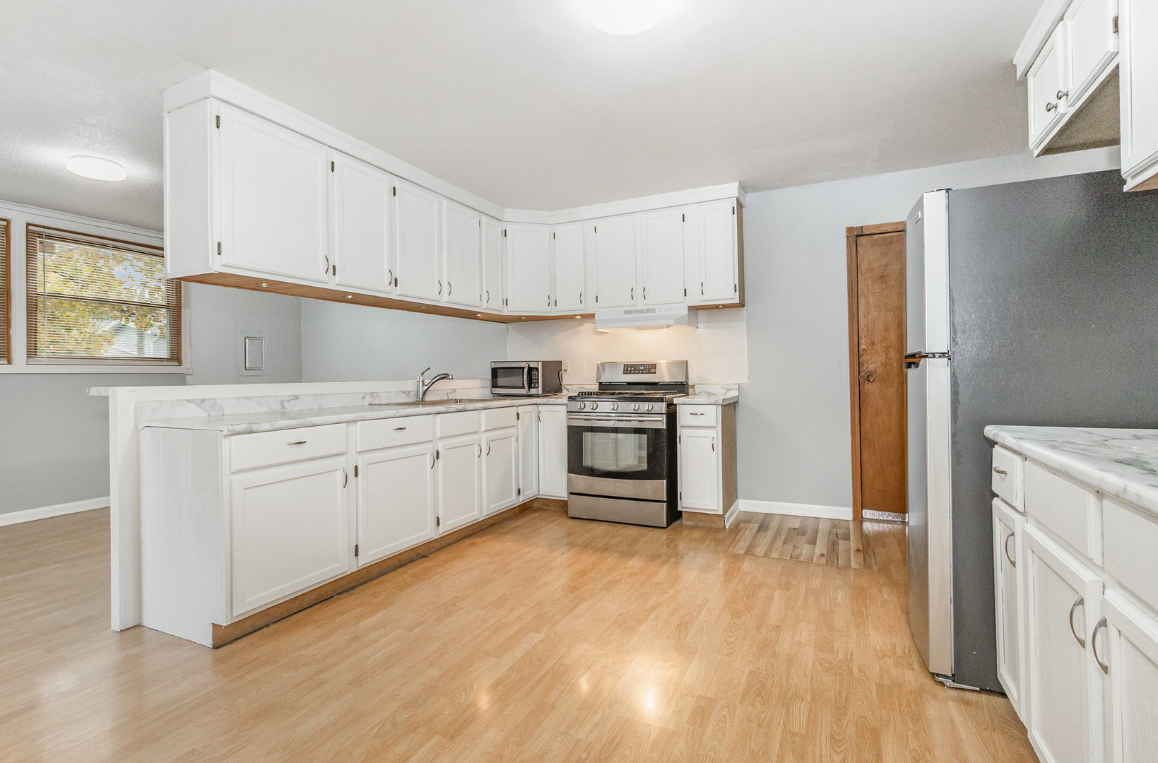 720 Union Avenue Romeoville, IL 60446 - Photo 8 of 15 a kitchen with white cabinets and white appliances
