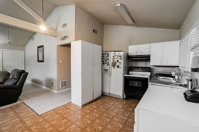 a kitchen with kitchen island a refrigerator stove and sink